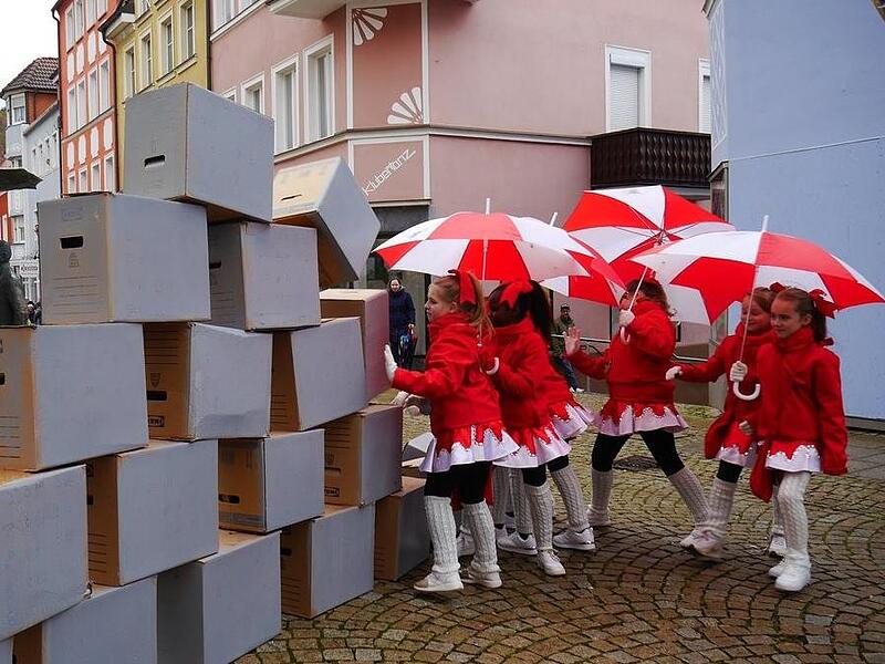Die Kindertanzgruppe „Rote Funken“ erstürmt die aus Pappkartons errichtete Stadtmauer höchst erfolgreich.