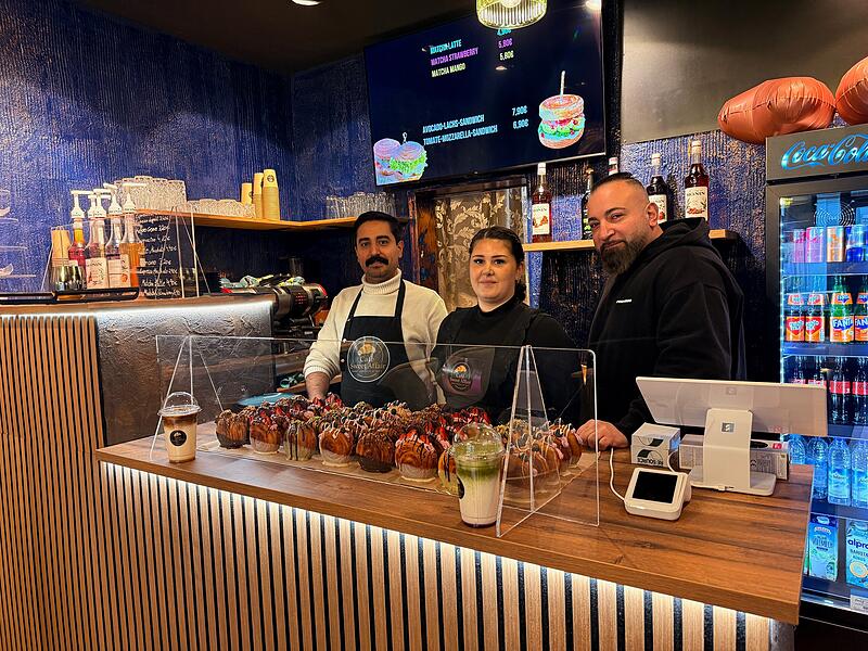 Isa Mohamed (links) mit seiner Konditorin und seinem Barista. Vor dem Personal entz&uuml;cken die New York Rolls - die Seele des neuen Caf&eacute;s,