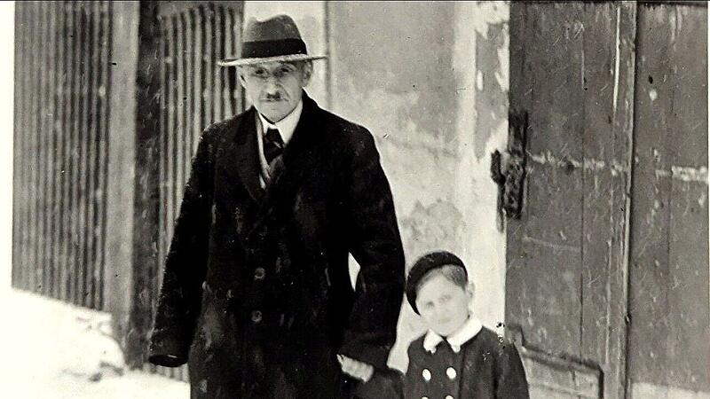 Die Fotografie von etwa 1949 zeigt Albert Schloß vor seinem Wohnhaus in Mühlhausen, zusammen mit dem etwa sechsjährigen Ralf Kriegel, dem Enkel von Frau Preussner, die eine Freundin der Eheleute Schloß gewesen ist.