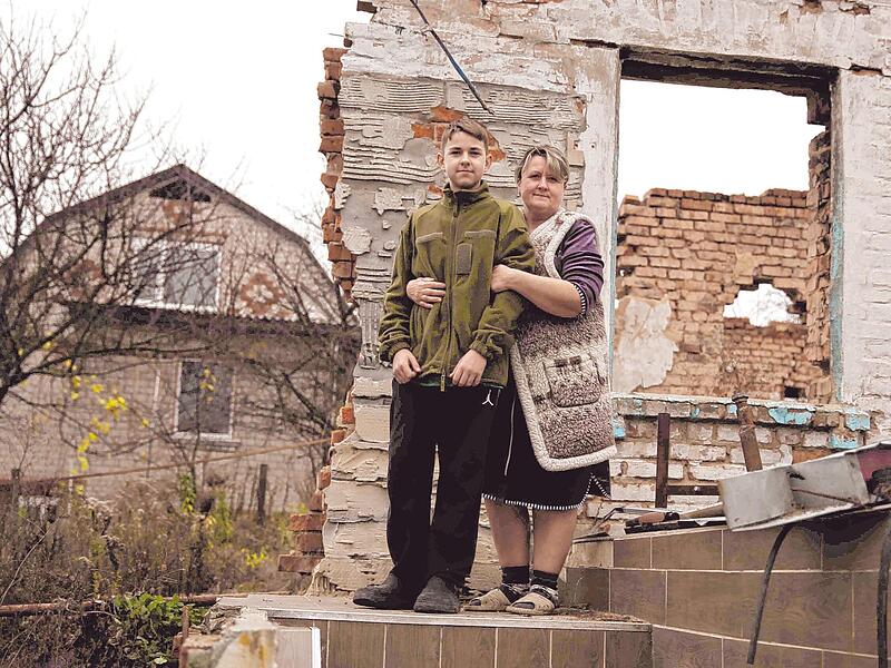 Alla und Arseniy auf den Resten ihres Hauses. Sie leben jetzt in einer Garage, viel Kleidung ist ihnen vor dem kalten Winter nicht geblieben. Alla und Arseniy auf den Resten ihres Hauses. Sie leben jetzt in einer Garage, viel Kleidung ist ihnen vor dem kalten Winter nicht geblieben.