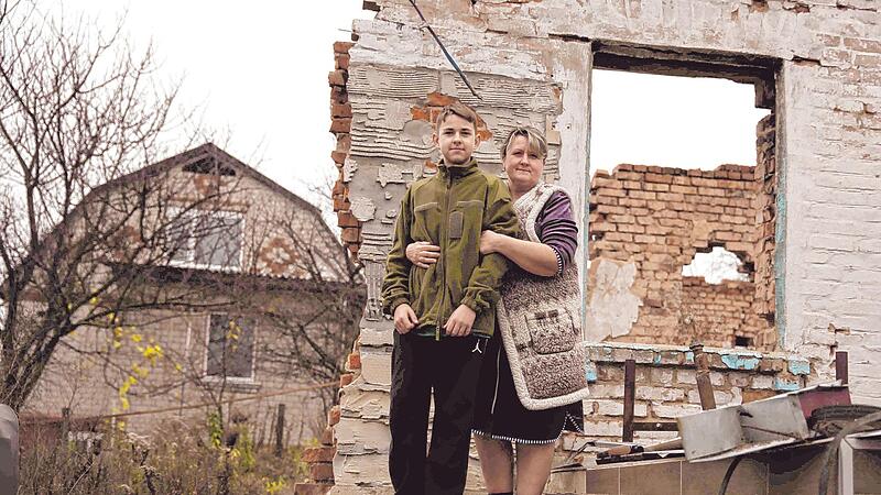 Alla und Arseniy auf den Resten ihres Hauses. Sie leben jetzt in einer Garage, viel Kleidung ist ihnen vor dem kalten Winter nicht geblieben.
