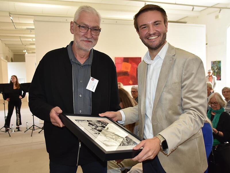 Landrat Jonas Gleich (rechts) bekam von Carsten Thom den Druck &bdquo;Markt Waafn&ldquo; &uuml;berreicht. Uschi Prawitz