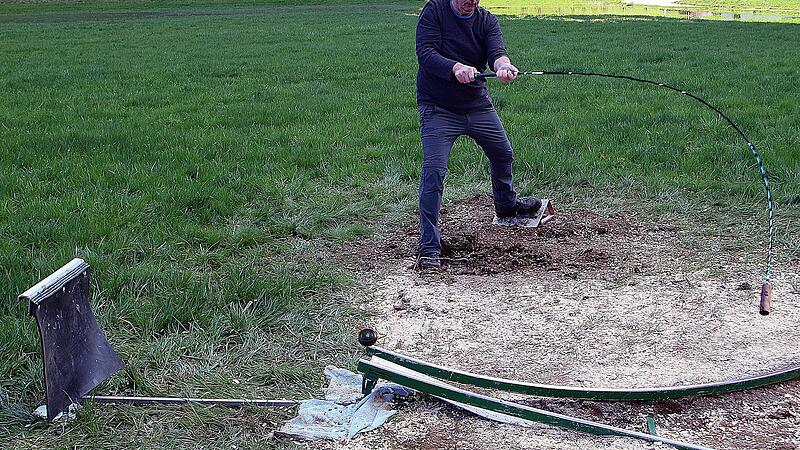 Von den beiden Metallschienen aus (je eine für Links- und Rechtshänder) wird der mit Lehm festgeklebte Nouss oder Hornuss von dem Spieler abgeschossen.