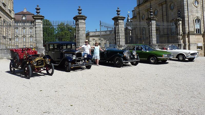 Georg und Uschi Weikert zwischen den Oldtimern vor Schloss Weissenstein in Pommersfelden.