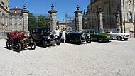 Georg und Uschi Weikert zwischen den Oldtimern vor Schloss Weissenstein in Pommersfelden.