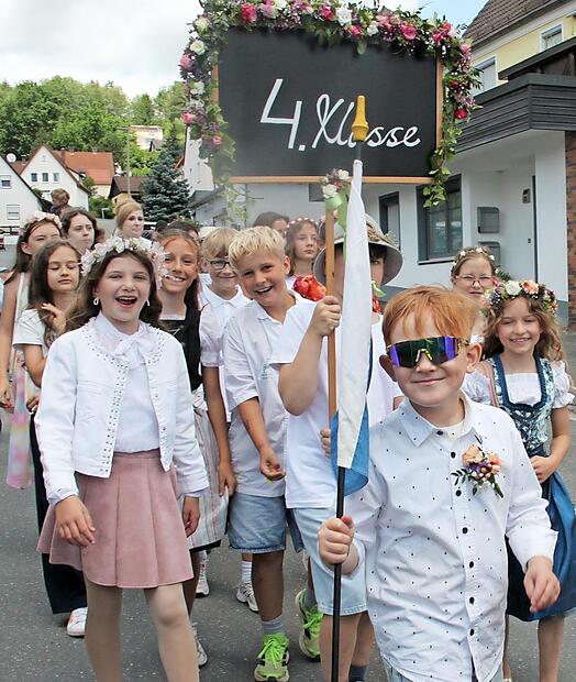 Ein bunter Zug schl&auml;ngelt sich beim Wiesenfest durch die Stra&szlig;en von Burghaig.
