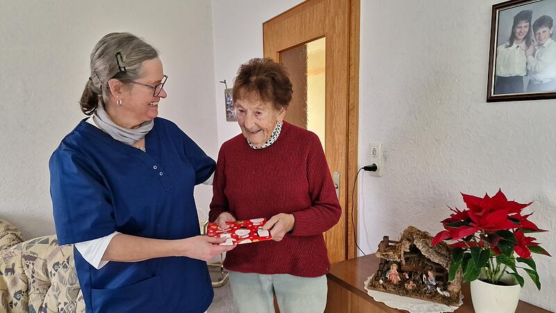 W&uuml;nsche zum Weihnachtsfest und ein kleines Geschenk. Pflegefachkraft Anja Vorndran und Erika Ziegler freuen sich gemeinsam.