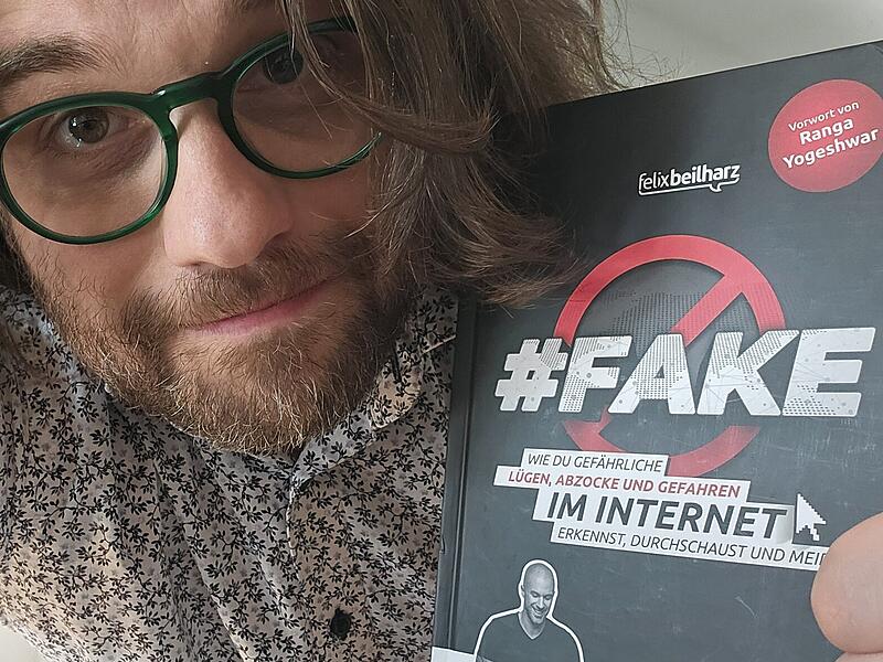 Kabarettist und Autor Florian Herrnleben mit dem Buch "Fake" von Felix Beilharz