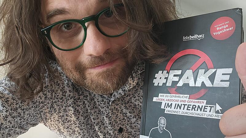 Kabarettist und Autor Florian Herrnleben mit dem Buch "Fake" von Felix Beilharz
