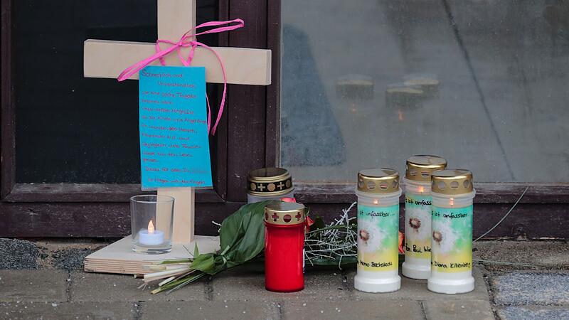 Kerzen, Blumen und ein Kreuz sind vor der Arztpraxis in Neudrossenfeld abgelegt worden.
