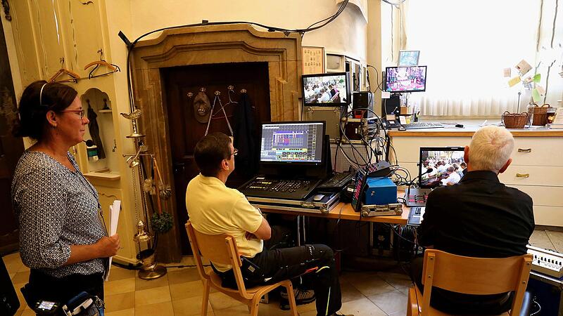 In der Sakristei verfolgen die Aufnahmeleiterin Berit Selzle und der kirchliche Beauftragte für den Bayerischen Rundfunk, Monsignore Erwin Albrecht, gespannt den Gottesdienst.