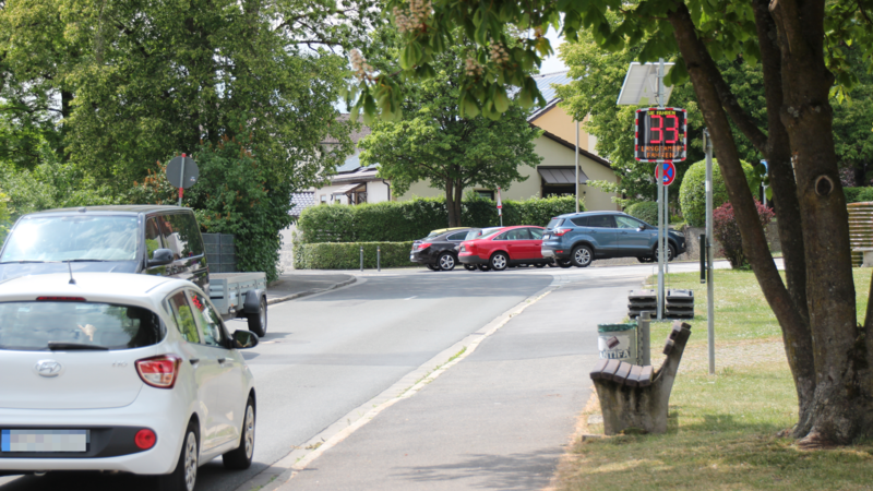 Geschwindigkeitsanzeigen sollen vor der Grundschule den Verkehr verlangsamen. Einige Autos bremsen ab, bis der Smiley gr&uuml;n lacht. Andere nicht.