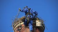 Als der Industriekletterer den Storchenhorst erreichte, flog der Altstorch auf.