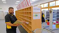 Freude über bessere Arbeitsbedingungen am neuen Standort: Tino Schärpf sortiert im neuen Zustellstützpunkt Hammelburg Briefe.