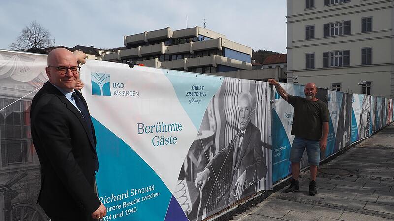Oberb&uuml;rgermeister Dr. Dirk Vogel (vorne) und Eigent&uuml;mer Robert Manhardt h&auml;ngen ein Banner an den Bauzaun.