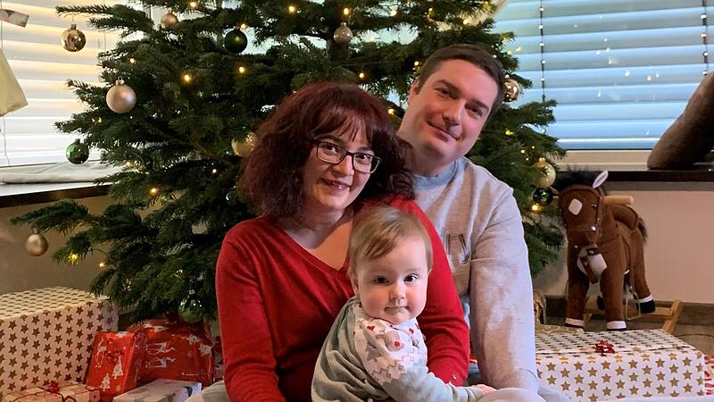 Corinna und Florian Fröhling tragen  ihr Sternenkind Zoe im Herzen und sitzen mit Maya, ihrer zweiten Tochter,   am Christbaum.