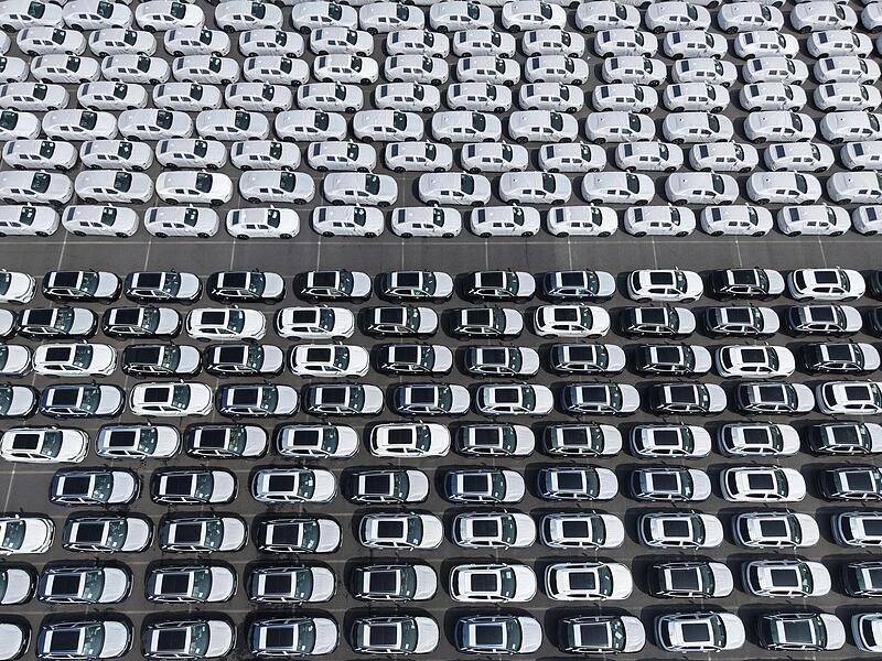 Neufahrzeuge stehen in einem Hafen in Shanghai f&uuml;r ihre Verschiffung nach &Uuml;bersee bereit (Luftaufnahme).  Bayerische Top-Branchen k&auml;mpfen gegen die &Uuml;bermacht aus China.  S&ouml;der warnt vor dramatischen Folgen.