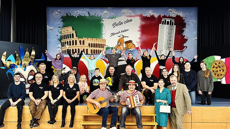 Mitwirkende und Helfer der &bdquo;Verflixten Sieben&ldquo; vor dem neuen B&uuml;hnenbild &bdquo;Bella ciao &ndash; St&auml;nich helau&ldquo;.