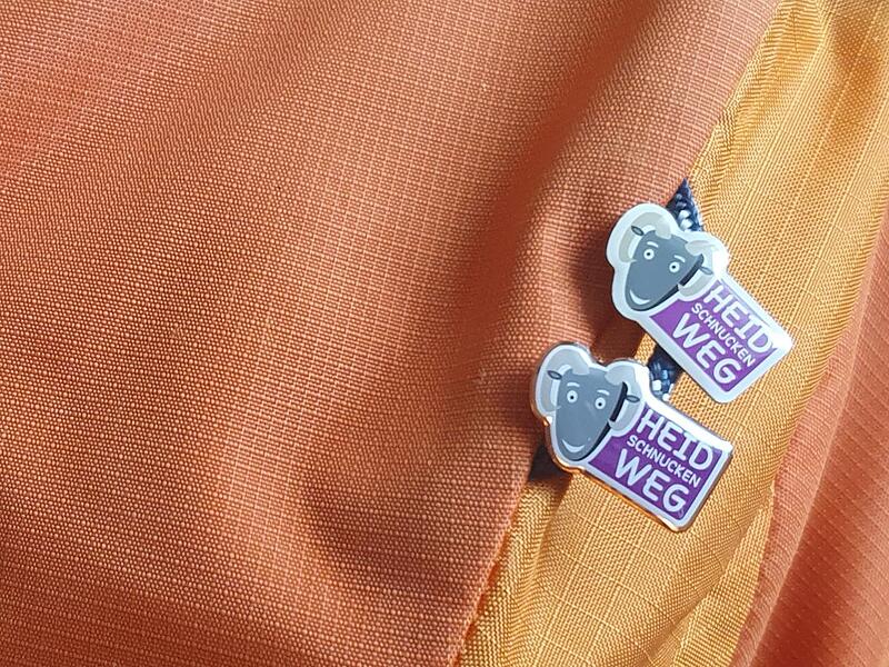 An den Rucksäcken von Christine Fischer und Sandra Zeitler hängen nun zwei Wander-Pins.