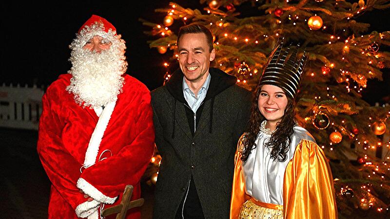 Erlaus Pfarrer Sebastian Schiller (Mitte) mit Weihnachtsmann und Christkind auf dem Erlauer Weihnachtsmarkt.