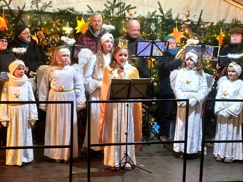 Christkind Jule und seine Engel begrüßen die Besucher auf dem Adelsdorfer Weihnachtsmarkt im Schlossgarten. Mit dabei Bürgermeister Karsten Fischkal und der Posaunenchor.