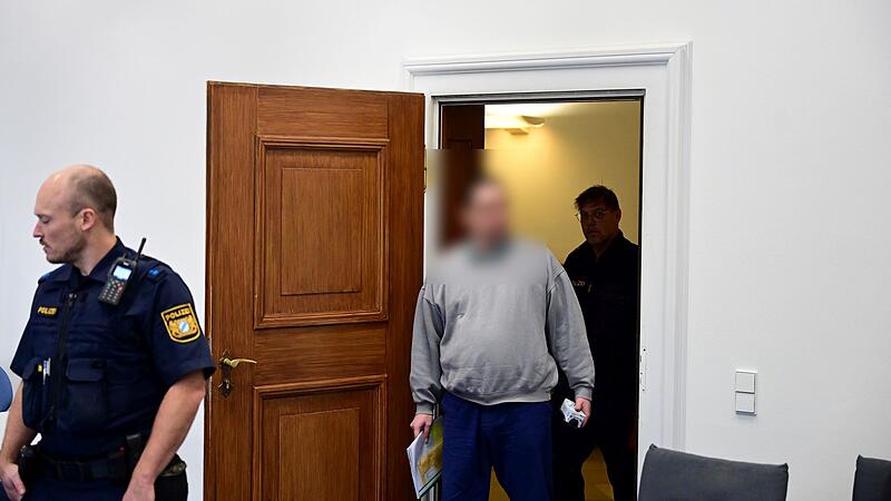 Der Angeklagte wird von zwei Polizeibeamten in den Gerichtssaal gef&uuml;hrt