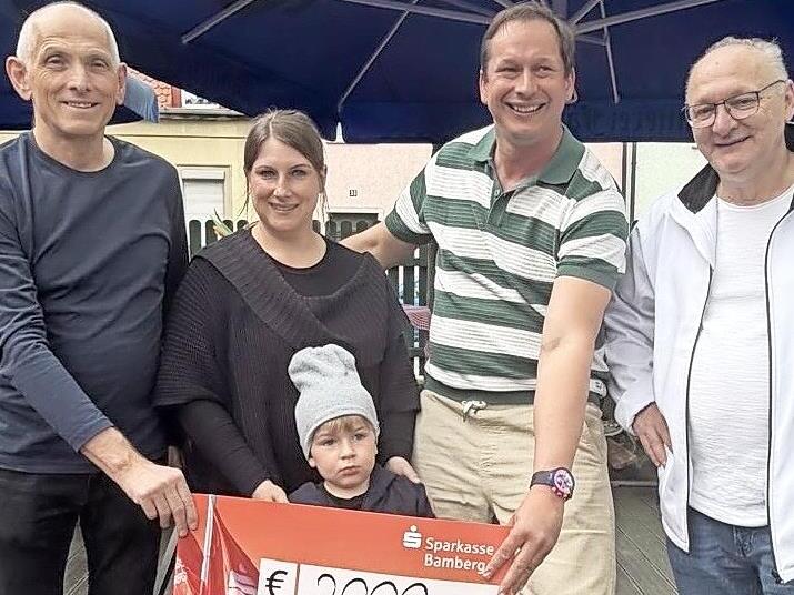 Premium-Partner Wolfgang Heyder (Veranstaltungsservice Bamberg), der kleine Charlie mit Mutter Astrid, Sebastian Linz (Kachelofen und F&auml;ssla-Keller) und Michael Amberg von der Kinder- und Jugendhilfe Memmelsdorf (v.l.) bei der Scheck&uuml;bergabe.