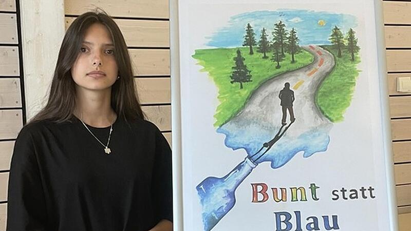 Fiona Sejdiu aus Haßfurt steht neben ihrem „bunt statt blau"-Gewinnerplakat.