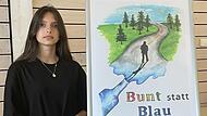 Fiona Sejdiu aus Haßfurt steht neben ihrem „bunt statt blau"-Gewinnerplakat.