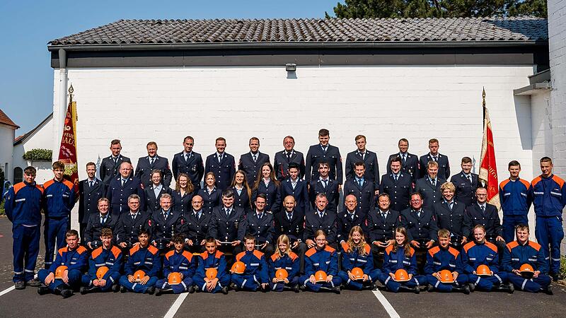 Die Aktiven der Freiwilligen Feuerwehr Ebenhausen (in Uniform) und vorne sitzend beziehungsweise  links und rechts an der Seite die Jugendfeuerwehr
