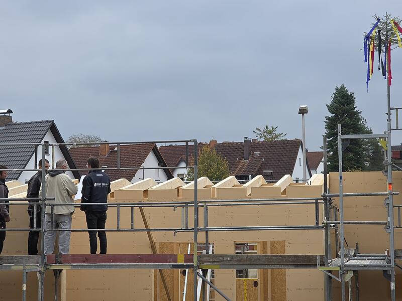 Mitarbeiter der Firma Seiler und der Architekt Lutz Wallenstein (2. von rechts) begutachten den bisherigen Baufortschritt. Der Richtbaum zeigt das erste Etappenziel an.