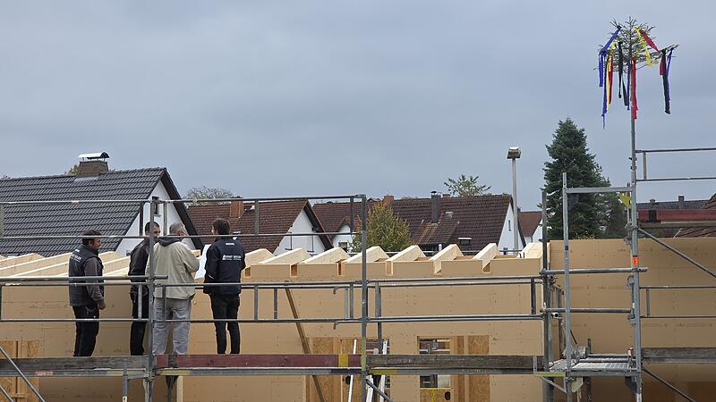 Mitarbeiter der Firma Seiler und der Architekt Lutz Wallenstein (2. von rechts) begutachten den bisherigen Baufortschritt. Der Richtbaum zeigt das erste Etappenziel an.
