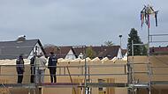 Mitarbeiter der Firma Seiler und der Architekt Lutz Wallenstein (2. von rechts) begutachten den bisherigen Baufortschritt. Der Richtbaum zeigt das erste Etappenziel an.