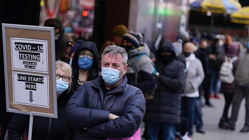 Menschen warten in einer Schlange vor einem Covid-Testzentrum am Times Square in New York. In den USA ist die Zahl der nachgewiesenen Infektionen mit dem Coronavirus seit Beginn der Pandemie auf mehr als 50 Millionen angestiegen.