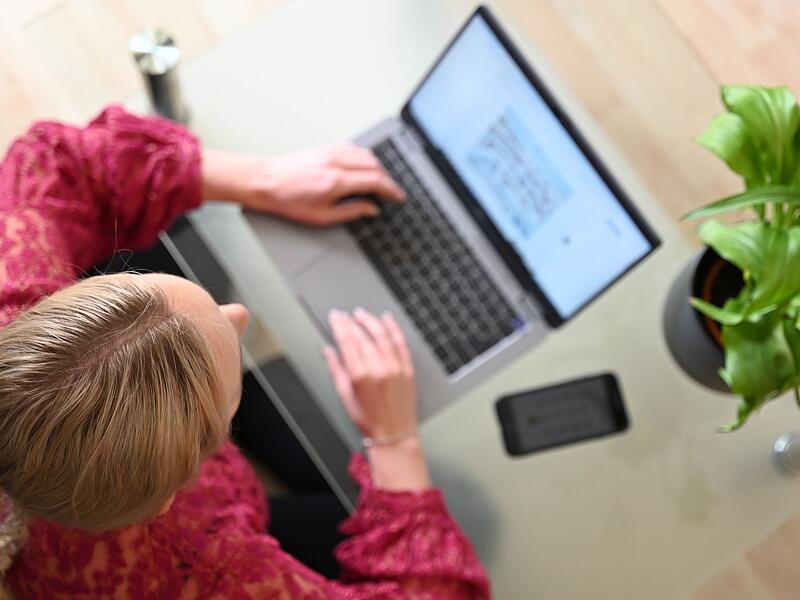 Eine Frau sitzt zuhause an einem Laptop