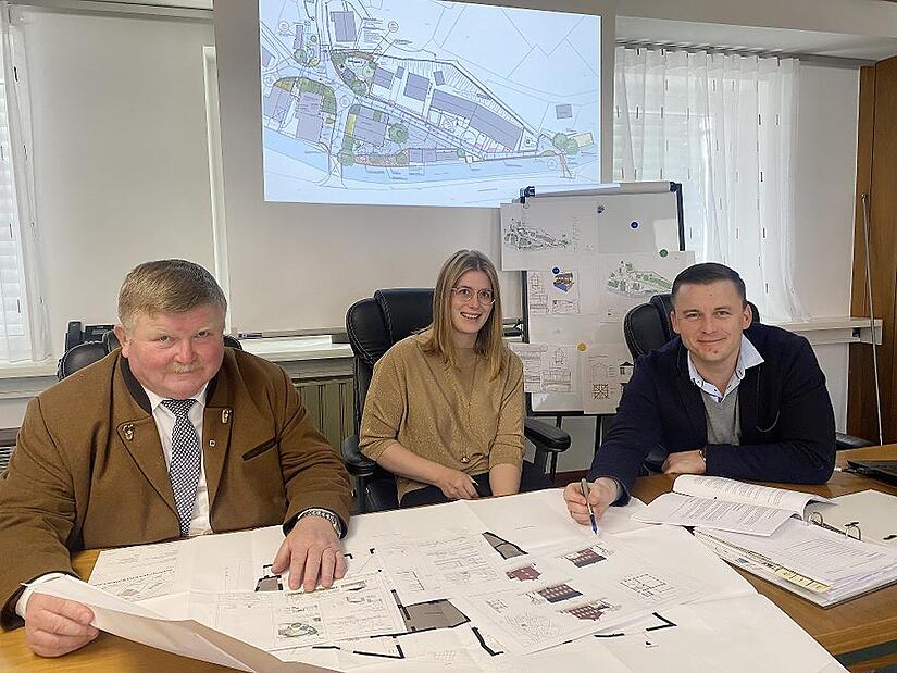 Sie zeigten sich nach der Marktgemeinderatssitzung glücklich über die Entscheidung für die einfache Dorferneuerung Förtschendorf. Von links Kreis- und Gemeinderat Reinhold Heinlein, die Ortssprecherin von Förtschendorf Christina Kropp und Bürgermeister Stefan Heinlein. Im Hintergrund der Gestaltungsentwurf für den Bereich der Dorferneuerung am Dorfplatz um Feuerwehrhaus und alte Schule.