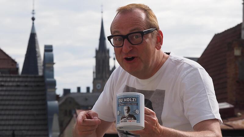 Unser Bild zeigt Volker Hei&szlig;mann mit seinem Gastgeschenk und der Kulisse von Bad Kissingen im Hintergrund.