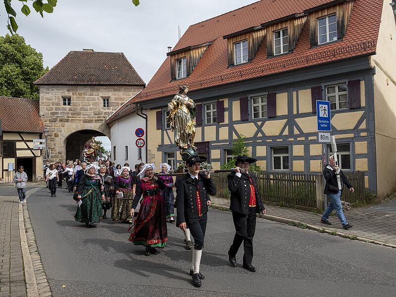 Vor dem historischen Forchheimer Tor tragen Mitglieder des Heimat- und Trachtenvereins Neunkirchen am Brand die Statue der heiligen Maria durch den Markt.