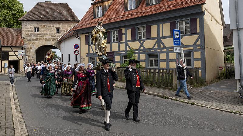 Vor dem historischen Forchheimer Tor tragen Mitglieder des Heimat- und Trachtenvereins Neunkirchen am Brand die Statue der heiligen Maria durch den Markt.