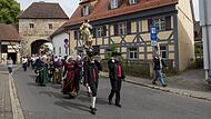Vor dem historischen Forchheimer Tor tragen Mitglieder des Heimat- und Trachtenvereins Neunkirchen am Brand die Statue der heiligen Maria durch den Markt.