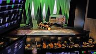 Blick aus der Beleuchterkabine auf die Bühne im Globe Coburg: Im Bühnenbild von Humperdincks „Hänsel und Gretel“ sitzen die Spartendirektoren (von links) Matthias Straub, Mark McClain, Daniel Carter und Neil Barry Moss.