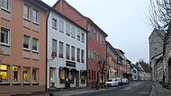 Innenstadt Münnerstadt In der Stadt reihen sich ein Elektrogeschäft, ein Bistro, ein Kleidergeschäft und ein Laden, der von Drogerie bis Eisenwaren alles bietet, nebeneinander. Der Gewerbeverein Kaufhaus Mürscht vertritt Gewerbetreibende wie diese Ladenbesitzer.