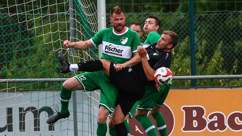 Mit erheblichem K&ouml;rpereinsatz h&auml;lt der Friesener Abwehrchef Manuel Friedlein (gr&uuml;n) seinen Gegenspieler Johannes Wittmann vom Ball weg.