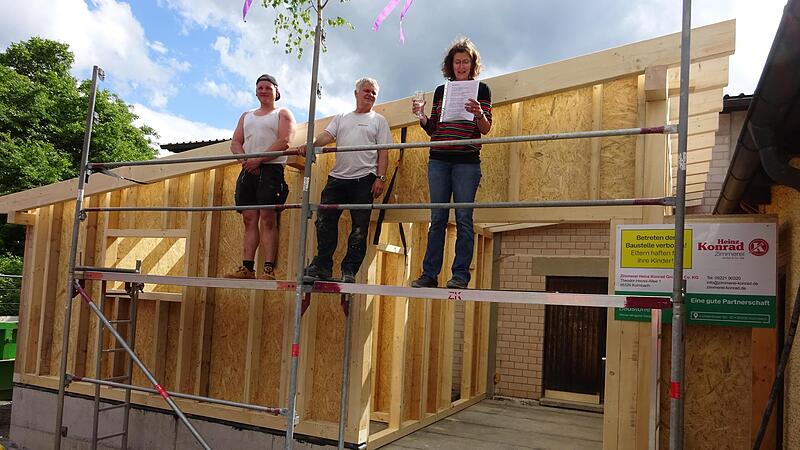 Die Holzkonstruktion f&uuml;r den Anbau steht. Katrin Mayer h&auml;lt im Beisein der Zimmerleute den Richtspruch.
