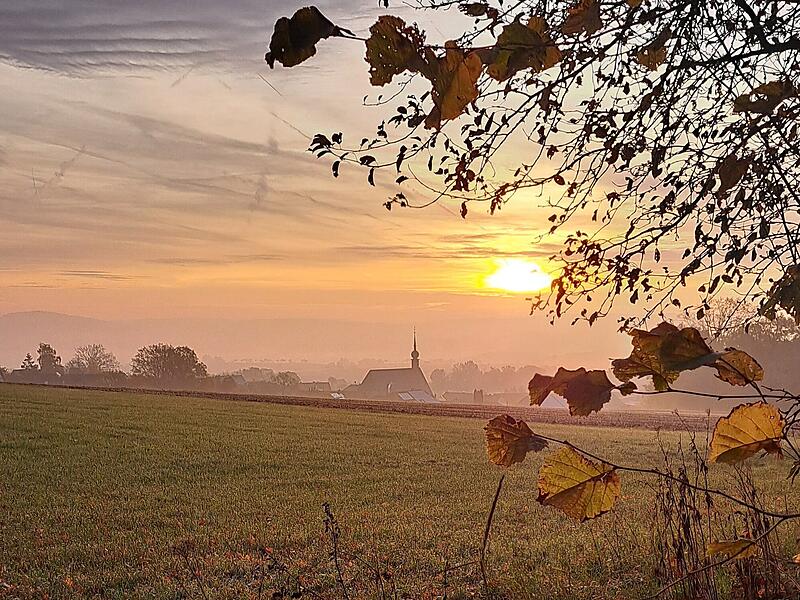 Herbststimmung: Sonnenaufgang in Modlos mit Blick auf die Kirche St. Jakobus.
