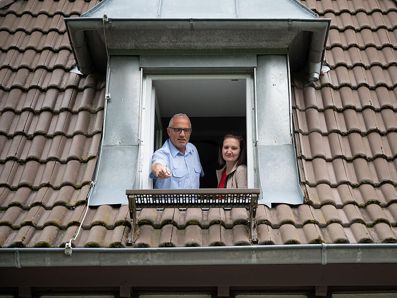 Kreisbrandrat Stefan P&uuml;ls mit Olga Denk vom Kommunalen Hochbau im Landratsamt  schauen aus einem Fenster des Kreisjugendheims.