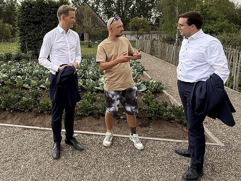 Hendrik Streeck (links) und Konrad K&ouml;rner (rechts) im Gespr&auml;ch mit einem Bewohner, der die landwirtschaftlichen Projekte der Laufer M&uuml;hle in Lauf vorstellt.