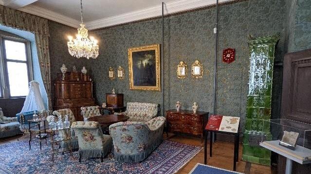 Im Blauen Salon des Graf-Luxburg-Museums ist in diesem Jahr das Tauschobjekt aus der Aktion „Kunst geht fremd“ zu finden. Präsentiert wird in unmittelbarer Nähe zur gräflichen Wiege (links im Bild) ein Kindbettzettel (rechts) aus dem Jüdischen Kul...