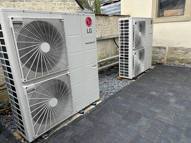 Die Wärmepumpe versteckt sich am Rand des Hofs an einer Mauer. Die Wärmepumpe versteckt sich am Rand des Hofs an einer Mauer.