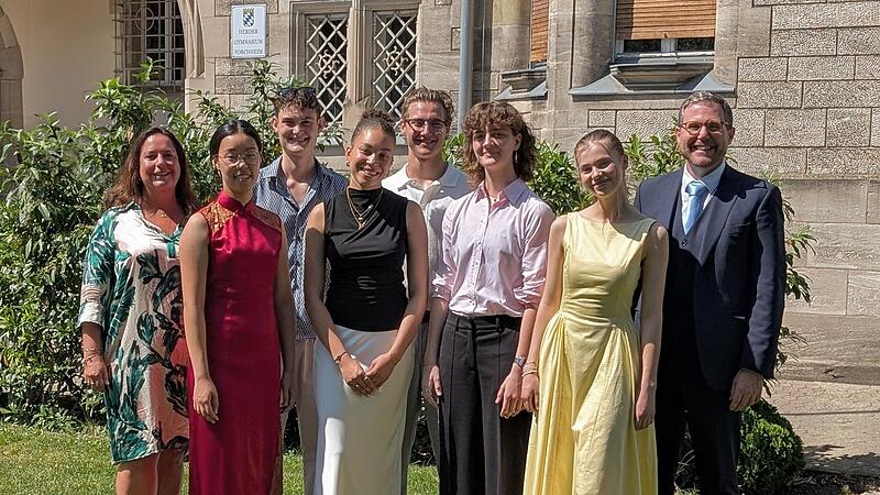 Die besten Absolventen des Abiturjahrgangs 2026 am HGF: (v.l.) Christina Ding (1,2), Joseph Walloch (1,2), Aimie Onwughai (1,0), David Burger (1,2), Amelie Borrmann (1,2), Matilda Geiling (1,2) gemeinsam mit Oberstufenkoordinatorin Yvonne Matzig-Reimann (links) und Schulleiter Dr. Bruno Kuntke (rechts).Forchheim & Fr&auml;nkische Schweiz